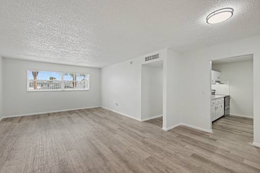 A room with a window and a wooden floor.