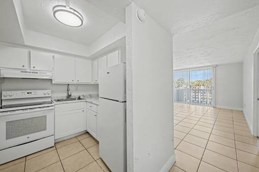 A kitchen with white appliances and cabinets.