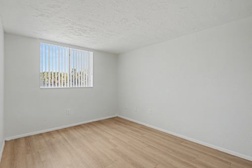 Empty room with wooden floor and a window.