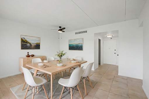A dining room with a table and chairs.