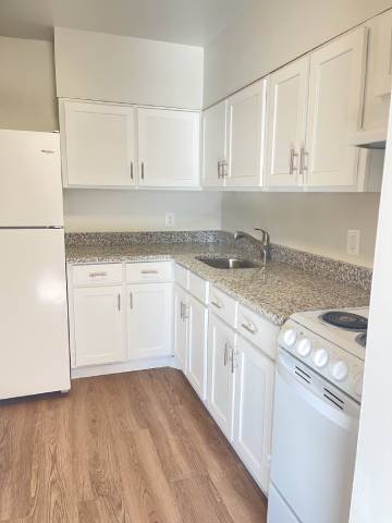 a kitchen with white cabinets and a stove and a sink