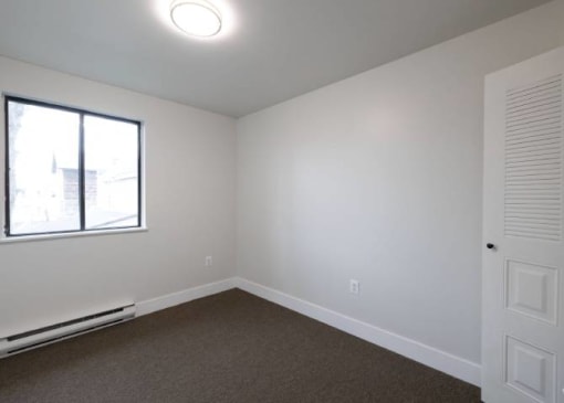 an empty room with carpet and a window
