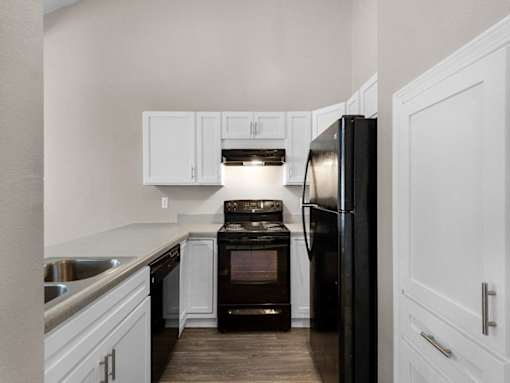 a kitchen with black appliances and white cabinets