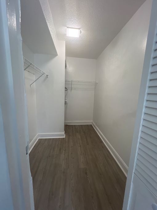 A white room with a wooden floor and a staircase.