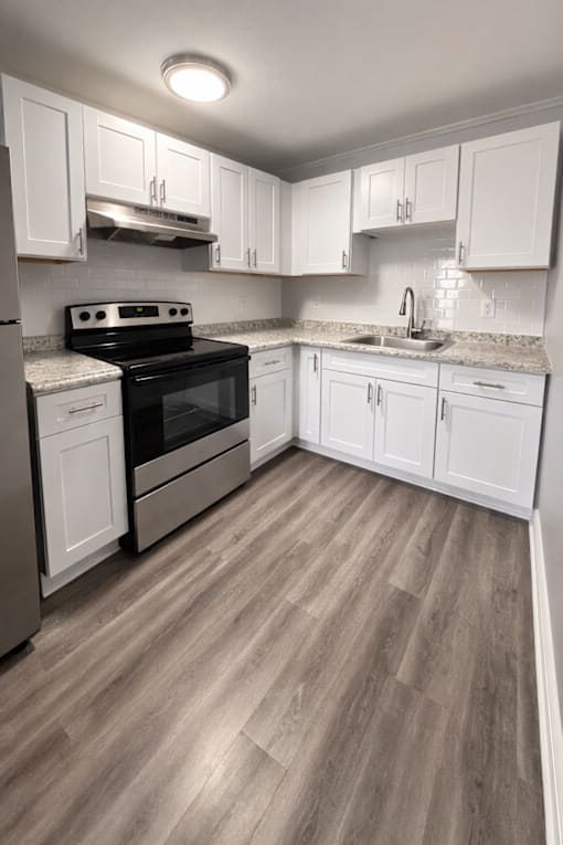 A kitchen with white cabinets and a black stove top oven.