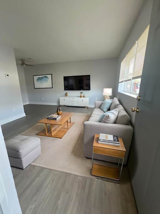 A living room with a white couch and a wooden coffee table.