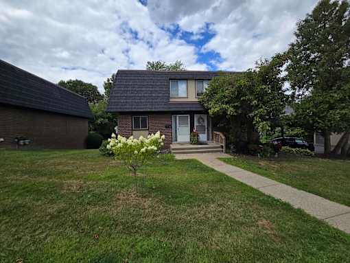 A house with a front yard and a flowering tree.