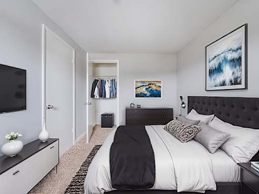 A bedroom with a large bed and a painting on the wall.