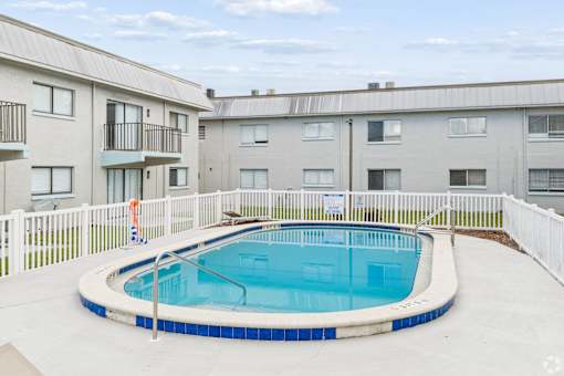 A small round pool with a white fence around it.