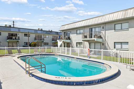 A small pool in a courtyard surrounded by apartment buildings.