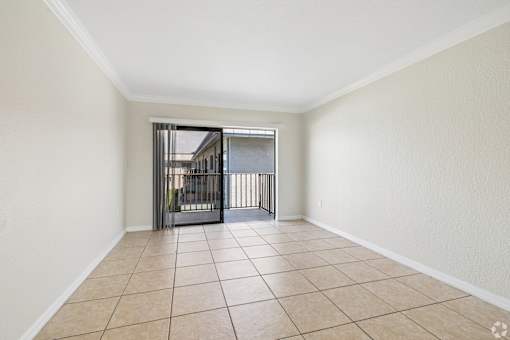A room with a tiled floor and a staircase with a metal railing.
