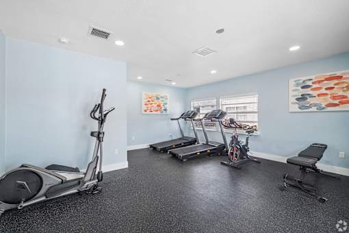 A spacious room with exercise equipment and a treadmill.