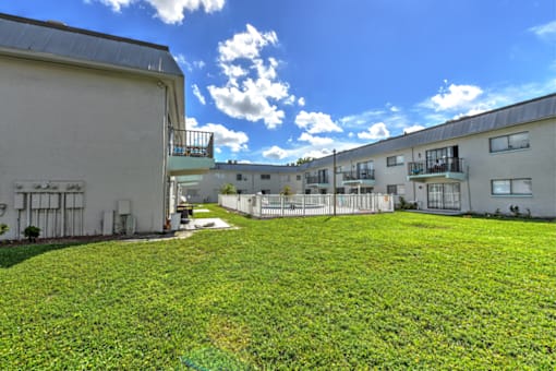 A grassy area in front of apartment buildings.