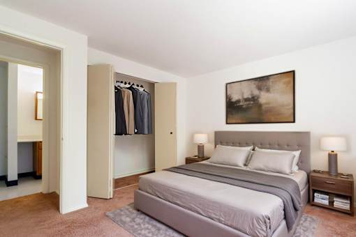 A bedroom with a large bed and a painting on the wall.