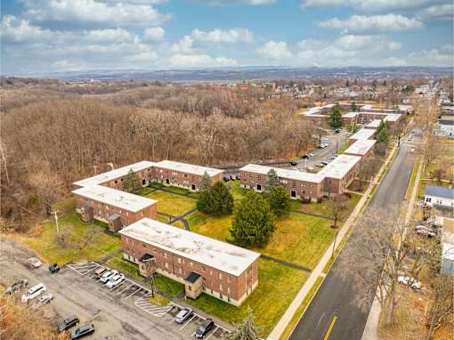 A large building complex with a parking lot in front.