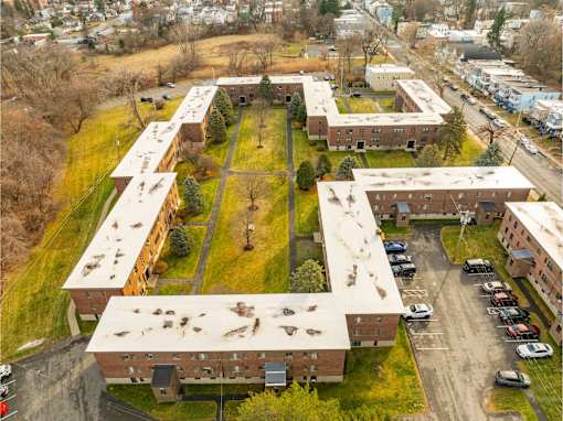 A parking lot is surrounded by apartment buildings.