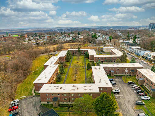 A large building complex with a parking lot in front.