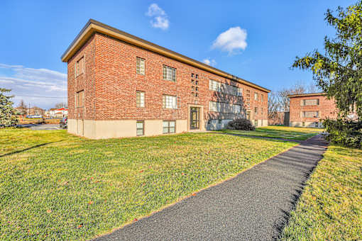 A red brick building with a green lawn in front.