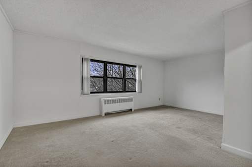 A room with a window and a radiator on the floor.