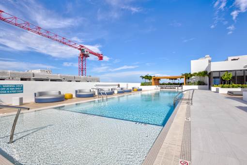 A large red crane is behind a swimming pool.