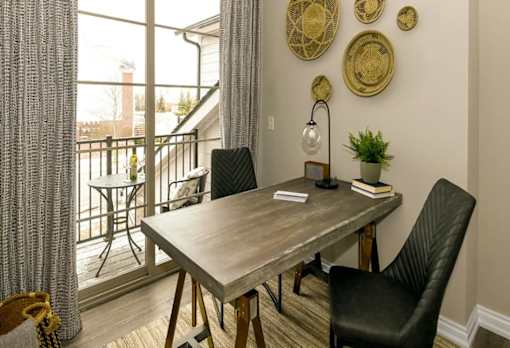 a dining room with a table and chairs and a balcony at Encore at Manchester, Michigan
