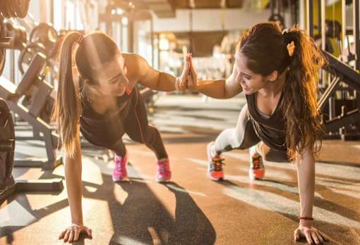 two women in a gym holding hands while doing push ups at Encore at Manchester, Novi, MI 48377