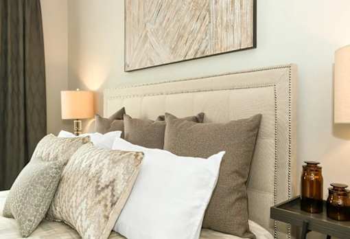a bedroom with a bed with pillows and a painting on the wall at Encore at Manchester, Michigan