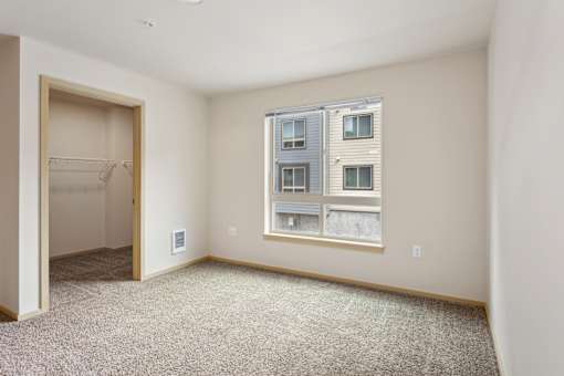 an empty room with a large window and a closet