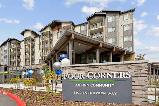 an hnn community sign in front of an apartment building