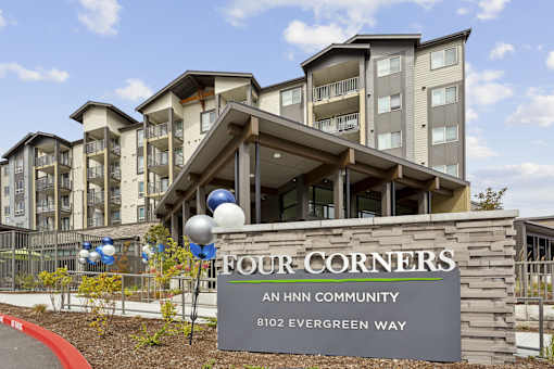 an hnn community sign in front of an apartment building