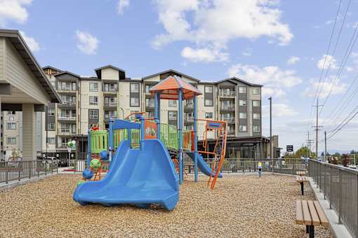 a playground at an apartment building with a blue slide