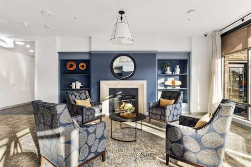 A living room with a fireplace and four chairs.