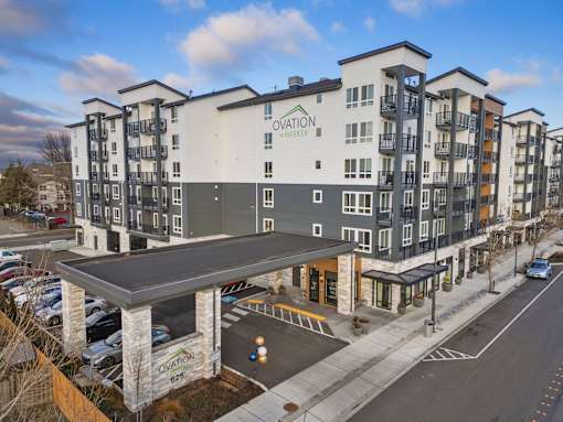 A modern apartment building named Ovation Meeker is shown.