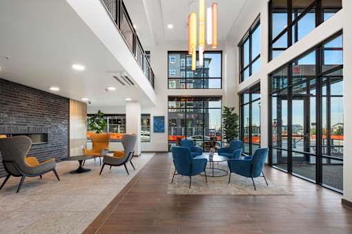A modern interior with a fireplace and blue chairs.