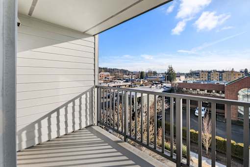 A balcony with a metal railing overlooks a town.