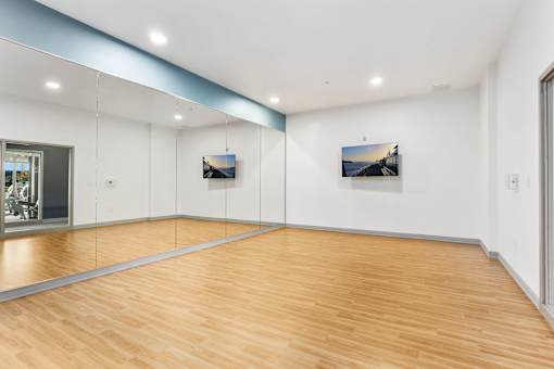 A room with wooden floors and two pictures on the wall.