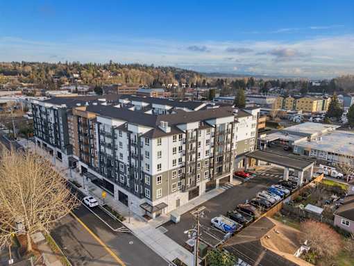 A large apartment complex with a parking lot in front.