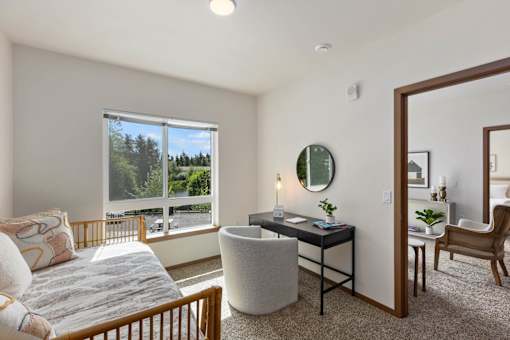 A bedroom with a large bed, a desk, and a chair.