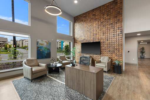 A modern office lobby with a reception desk and comfortable seating.