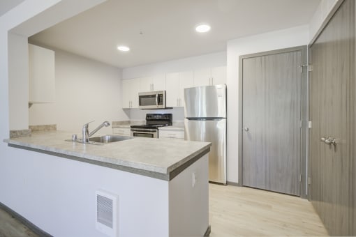 Kitchen with refrigerator, oven, microwave, and sink