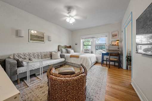 A living room with a grey sofa and a patterned armchair.