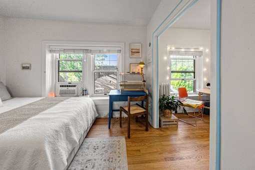 A bedroom with a bed, desk, and chair.