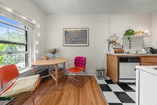 A kitchen with a table and chairs by a window.