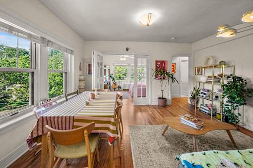 A sunny day in a well-lit room with a long table and chairs.