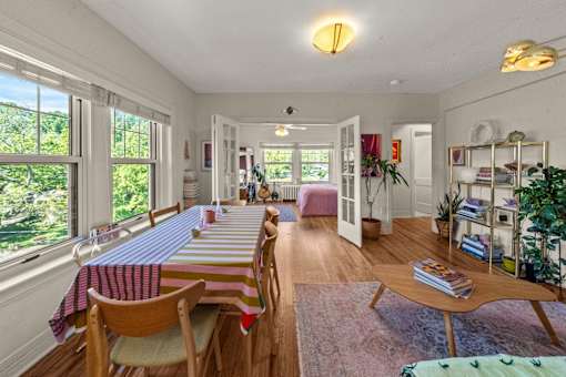 A dining room with a long table and chairs.