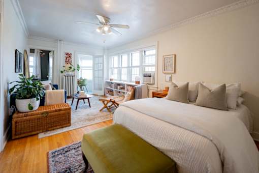 A bedroom with a large bed and a ceiling fan.