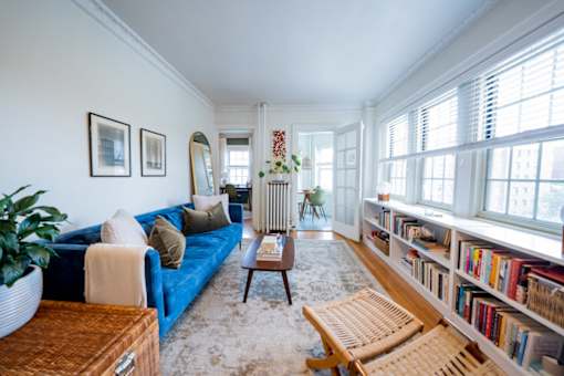 A living room with a blue couch, a wooden coffee table, and a bookshelf filled with books.