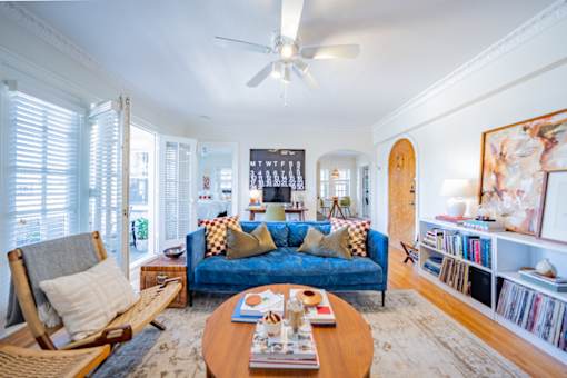 A living room with a blue couch and a wooden coffee table.