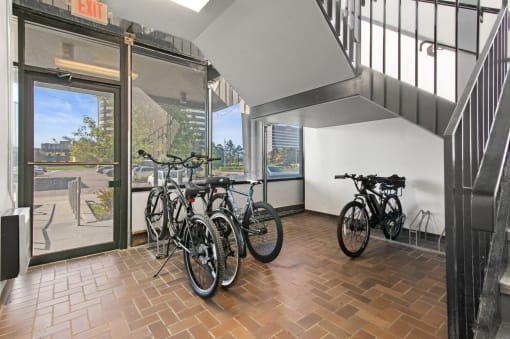 a group of bikes parked in a room next to a window