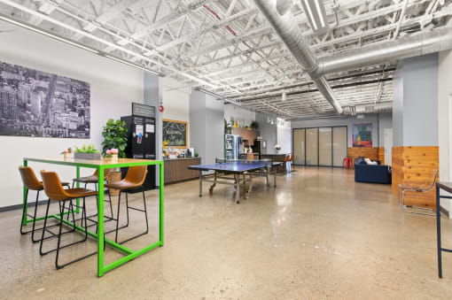 a large room with tables and chairs and a ping pong table